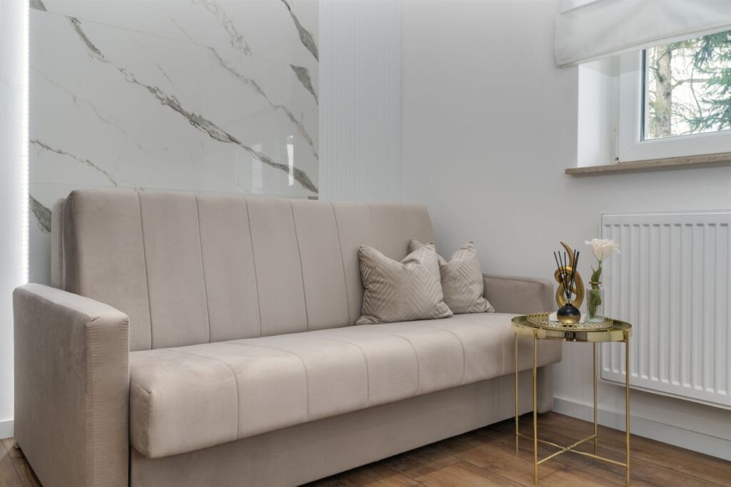 A stylish and minimalist living room featuring a neutral sofa and elegant decor.